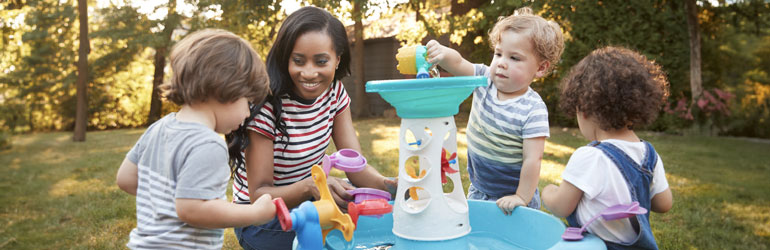 Toddlers playing around a water table
