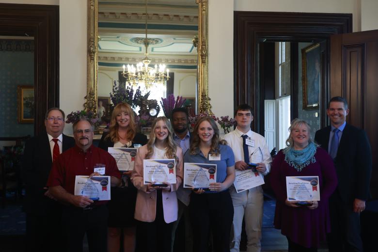 Breaking Traditions winners holding their awards with DESE team members. From left to right: Roger Barnes, Terry Brookshire, Tiffany Werts, Allyson Rogers, Mpumelelo "Leo" Matsebula, Madelyn Throckmorton, Jacob Vandeven, Hollie Silberhorn, Travis Plume