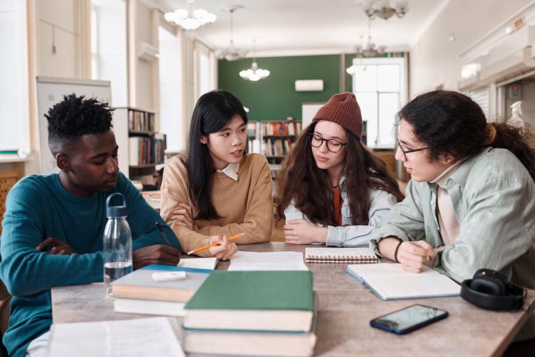 Four students at a table with books