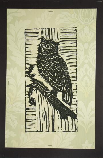 A black painted stencil of an owl on a branch with a light green leafy background by Janiya